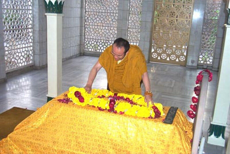 H.H. the 12th Taisitu Rinpoche placing flowers on Hazrat Inayat Khan's grave